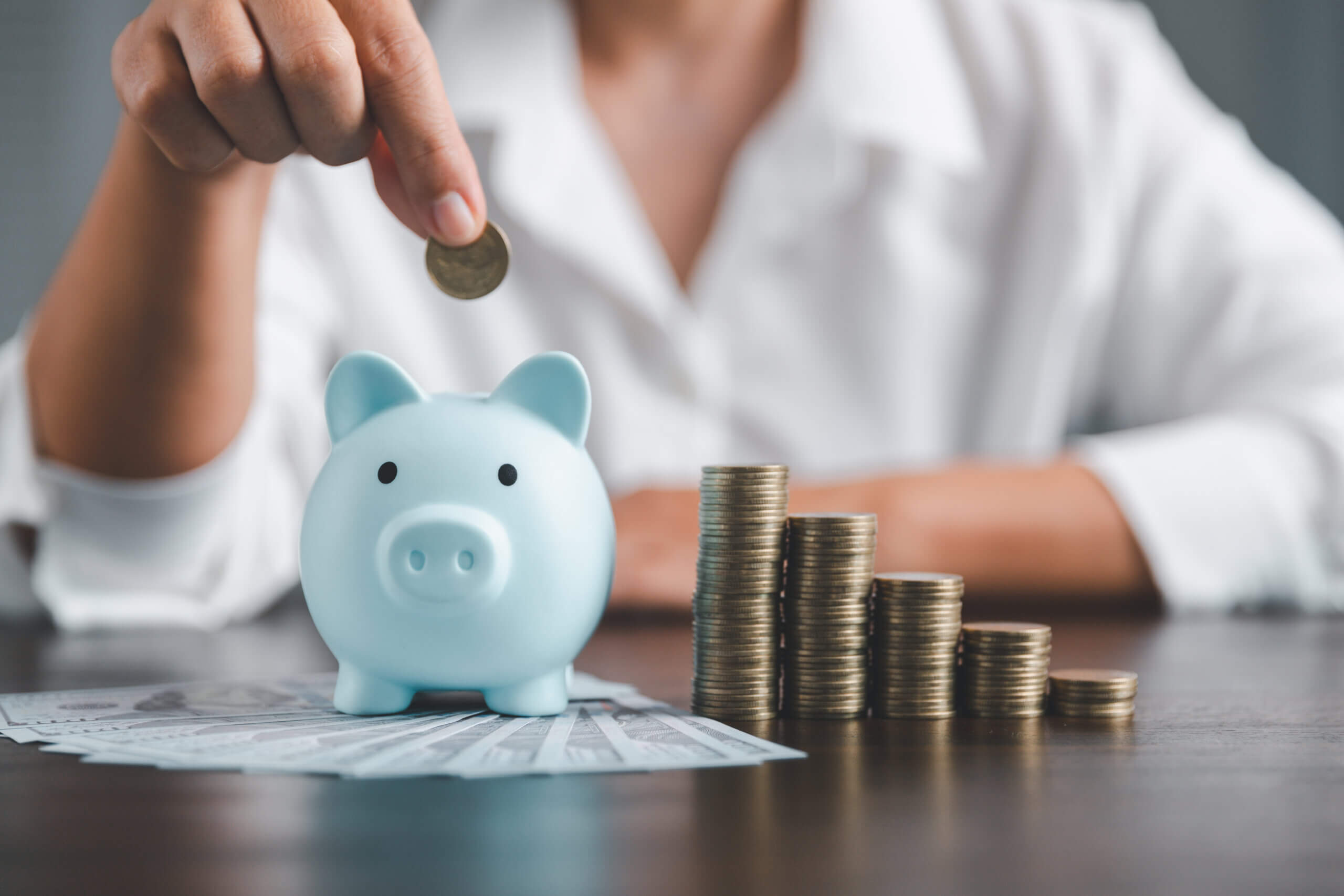 woman putting money in a piggy bank