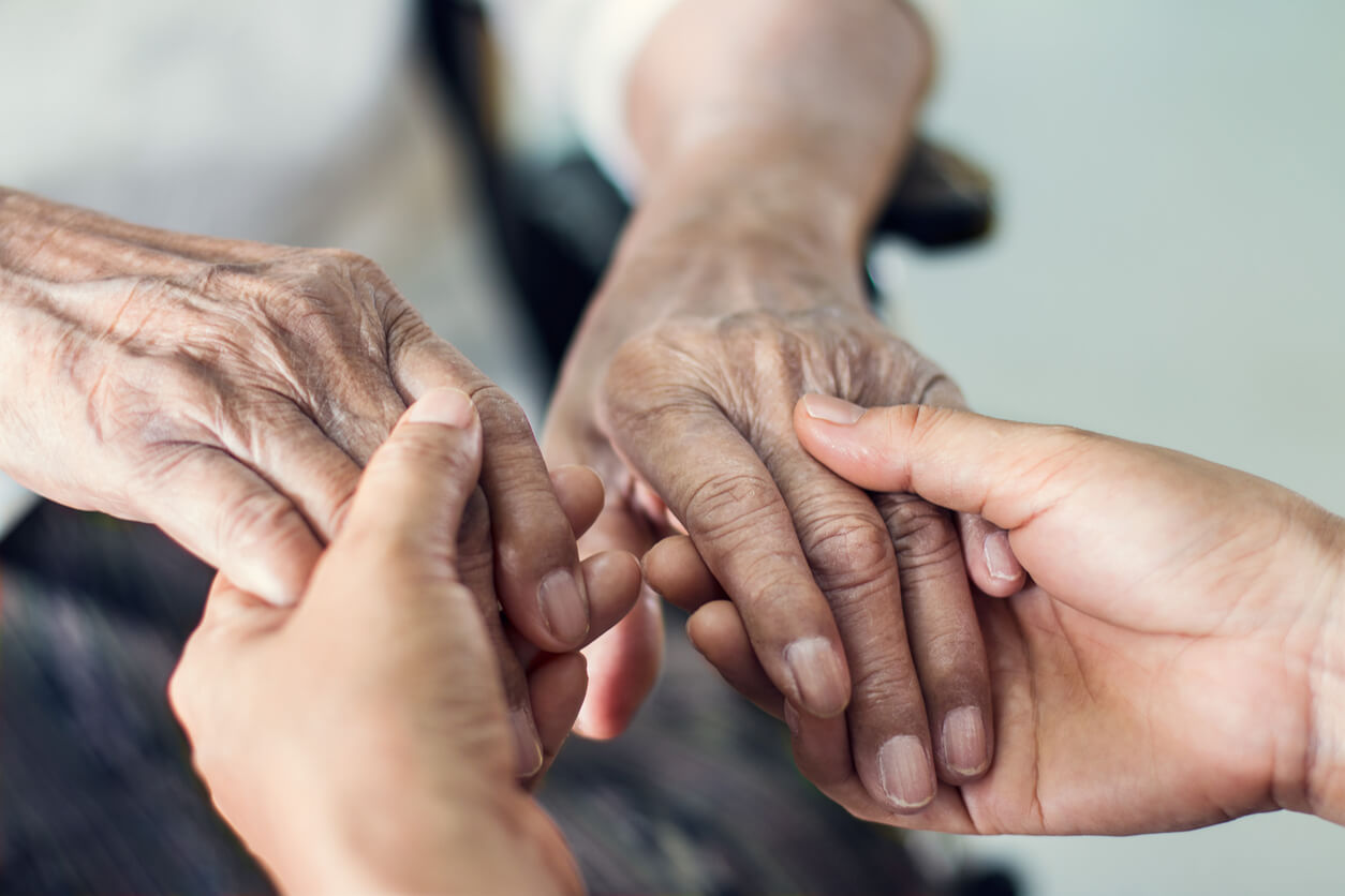 someone holding elderly parent's hands
