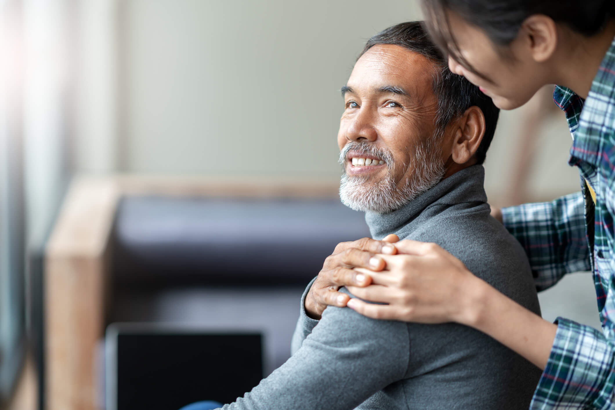 Adult daughter embraces her senior father