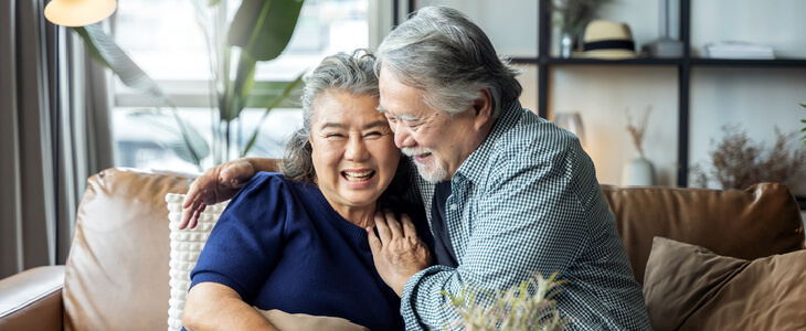 Elderly couple embracing each other and smiling