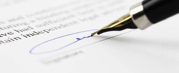 Close-up picture of a pen signing a paper