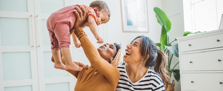 LGBTQ couple hugging a baby