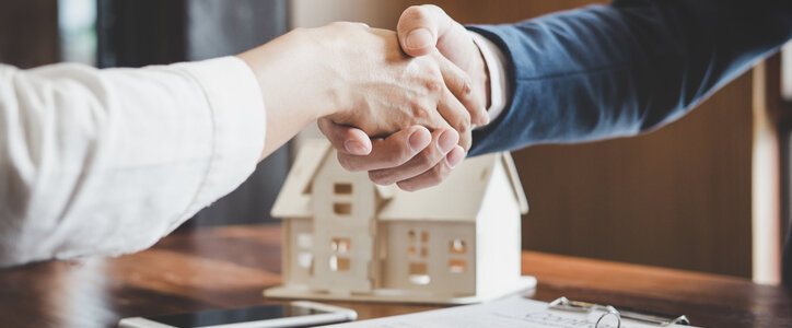 Real estate agent shaking a customers hand after purchasing a home