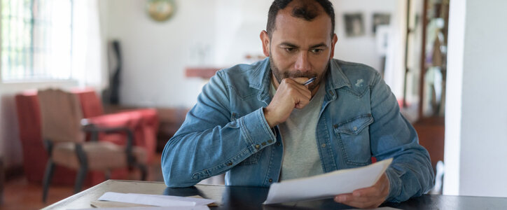 Stressed man checking his bills at home