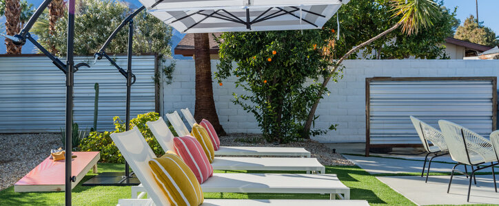 Backyard outdoor chaise lounge chairs with cantilever umbrellas and colorful pillows in Palm Springs, California