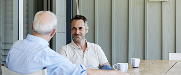 Mature man with father spending leisure time on patio