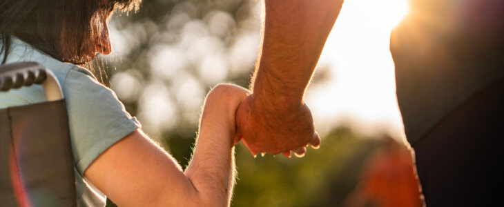 Close up women on a wheel chair holding mens hand