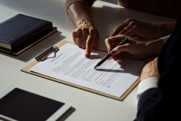 Female lawyer explaining the will to senior woman. Close up of hands, unrecognizable people.